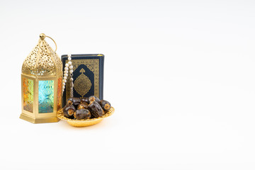 Lantern, Dates, Koran and Rosary on white background with selective focus and crop fragment. Ramadan, Religion and Copy space concept