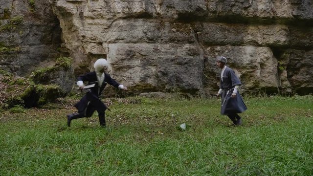men in dagestan circassians and sheepskin hats demonstrate national fight against stone gorge rocks slow motion