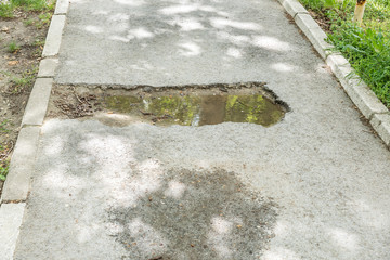 Pot hole, Dangerous damaged sidewalk for pedestrians with pothole full of water