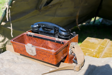 old military wired phone stands on the table in the army tent