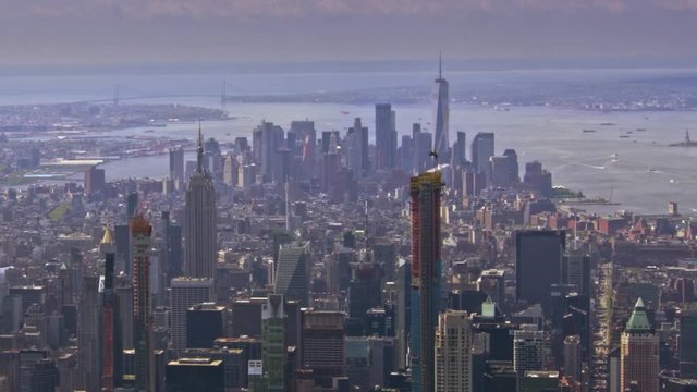 New York city aerial footage with midtown in foreground and lower manhattan in the distance. Also showing Verrazano bridge and statue of liberty.