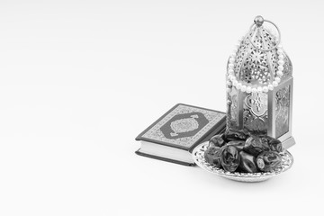 Lantern, Dates, Koran and Rosary on white background with selective focus and crop fragment. Ramadan, Religion and Copy space concept. Black and White concept