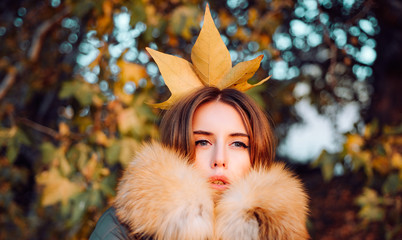 Woman feeling as autumn queen. Fall season outfit. Modern fashion outfit. Autumn season. Gorgeous pretty woman in furry coat fallen leaf on head as crown. Trendy outfit. Her confidence is stunning