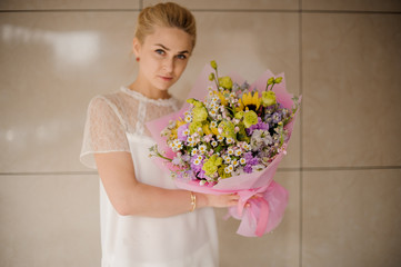 Young girl with astonishing bouquet with daisies