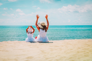 happy mom with little daughter have fun on beach