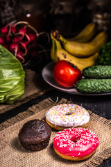 Donuts and chocolate muffin on burlap.