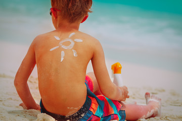 sun protection- boy with suncream at beach