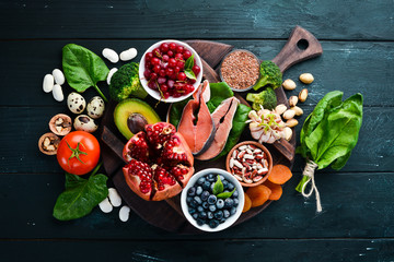Healthy food: Fish, blueberries, nuts, pomegranate, avocados, tomatoes, spinach, flax. Concept of...