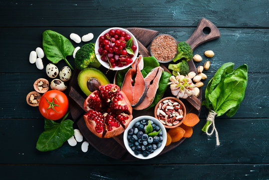 Healthy food: Fish, blueberries, nuts, pomegranate, avocados, tomatoes, spinach, flax. Concept of Dietary Nutrition. Top view.