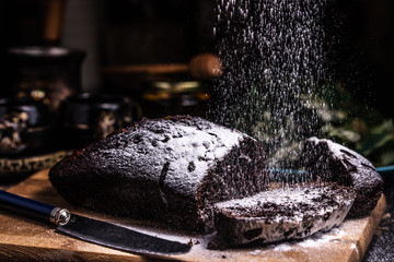 Pieces of chocolate cake on a wooden board. Powdered icing. Chocolate Brownie.