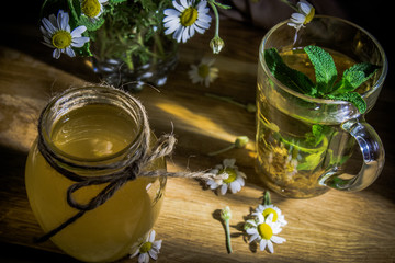 Soothing tea with honey and mint in a beautiful setting on a wooden board