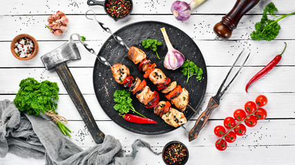 Barbecue chicken on skewers with onions and tomatoes. Barbecue. Top view. Free space for your text. Rustic style.