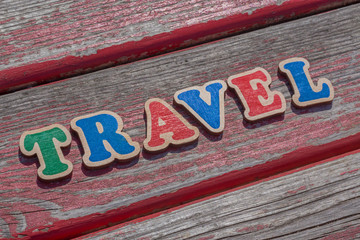 word travel made of color wooden letters on wood board