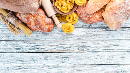 Gluten free food. Various pasta, bread, snacks and flour on a white wooden background. Top view....