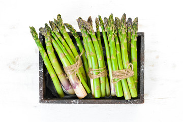 Fresh asparagus in a wooden box. Healthy food. Top view. Free space for your text.