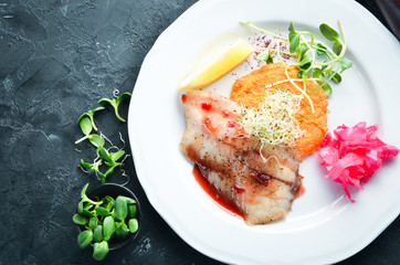 Baked fish fillet with mashed sweet potatoes. In the plate. Top view. Free space for your text. Rustic style.