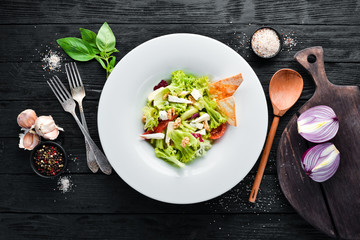 Vegetable salad with cheese, olives and cherry tomatoes. In the plate. Top view. Free space for your text. Rustic style.