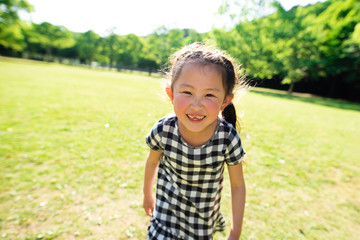 芝生で遊ぶ笑顔の女の子