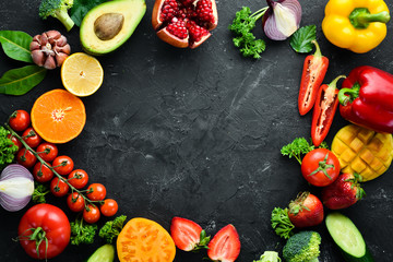 Fresh fruits, vegetables and berries. On a black background. Banner Top view. Free space for your...