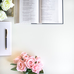 lifestyle flat lay with different accessories; flower bouquet, pink roses, open book, Bible, pen, journal, etc. Basel Land, Switzerland - April 12, 2019