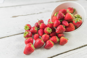 Fresh strawberries fruit on white wood table.