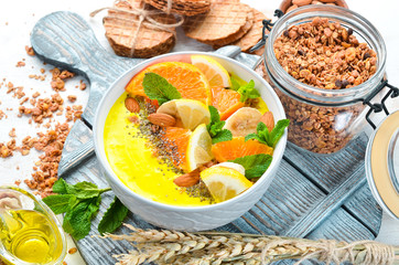 Smoothie bowl with orange, banana, lemon and almonds. Breakfast. Top view. Free space for your text.