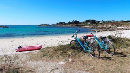 Deux vélos garés à l’entrée d’une plage déserte sur l’île de Batz, en Bretagne (France)