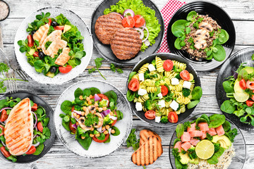 A set of delicious restaurant dishes on a white wooden background Top view. Free space for your text. Flat lay