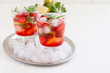 
Summer cold drink . Lemonade with mint and strawberries on a light background.
