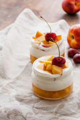 Summer dessert of peaches and yoghurt with a sweet cherry, selective focus