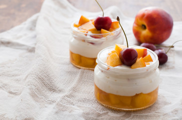 Summer dessert of peaches and yoghurt with a sweet cherry, selective focus