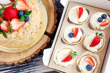 Honey cake decorated with bright strawberries and blueberries. Festive party cakes for birthday, wedding.