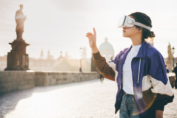 Woman wearing vr headset augmented virtual reality in history city center. Concept of virtual...