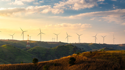 Wind turbines and Orange sunset sky. Beautiful mountain landscape with wind generators...