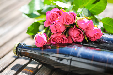 Beer bottle lying with roses for Father's Day