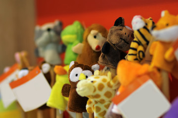 Toy puppets on wooden sticks for preschool nursery theatre, standing in a row. Puppet theatre art.