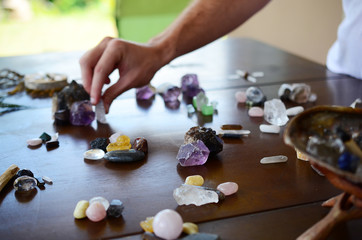 Beautiful Clear Quartz, variety of crystal on wood table. Bright Quartz crystal, healing crystal being held in hand. Woman holding quartz tower, crisp colors in natural lighting. Vibrant meditation.