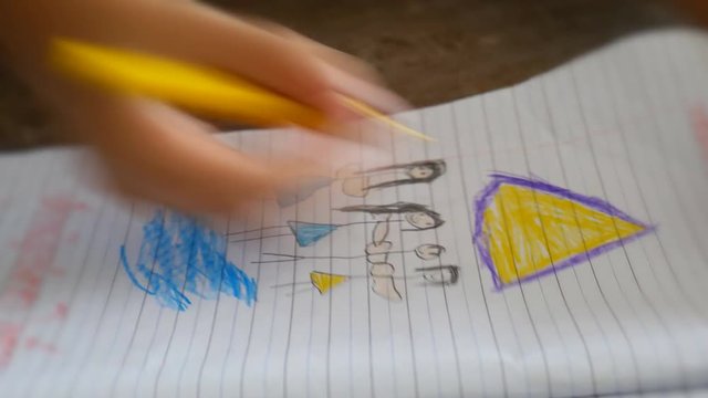 Hand clpse up of children to draw cartoons on paper
