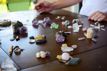 Beautiful Clear Quartz, variety of crystal on wood table. Bright Quartz crystal, healing crystal being held in hand. Woman holding quartz tower, crisp colors in natural lighting. Vibrant meditation.