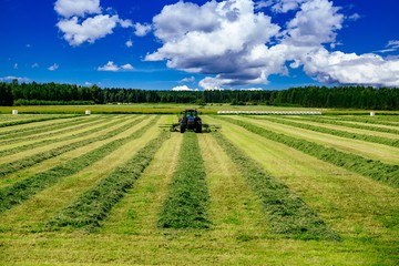 Aerial view of Tractor mowing green field in Finland.