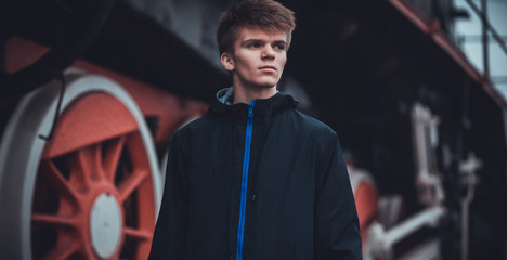 Young student man wait on Old Steam Train. Travel concept. future engineer technologist