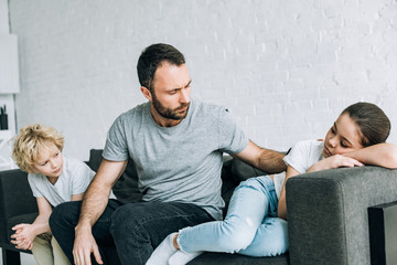 two sad preteen children and father having conflict