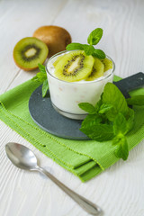 Homemade proteic greek yogurt with kiwi, lemon and mint and healthy shack of kiwi, banana and lemon