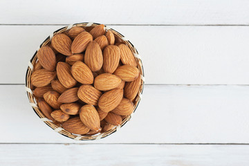 Almonds nuts in wooden bowl on wood table,Top view.