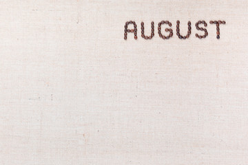 The word August written with coffee beans shot from above, aligned at the top right.