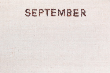The word September written with coffee beans shot from above, aligned at the top.