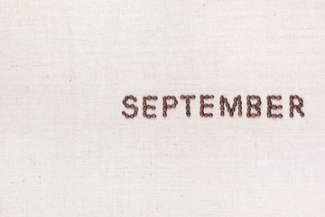The word September written with coffee beans shot from above, aligned to the right.
