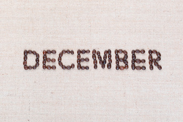 The word December written with coffee beans shot from above, aligned in the center, closeup.