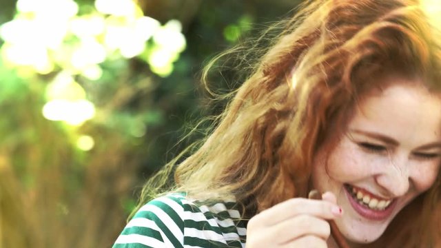 Beautiful woman with freckles playing with honey spoon