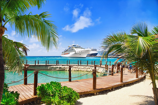 View from beach at tropical resort on cruise ships docked at port 